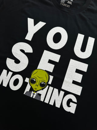 Black t-shirt with white text and a green alien graphic on a black background